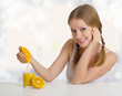 girl squeezes the juice from the orange