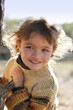 Little girl stood by tree
