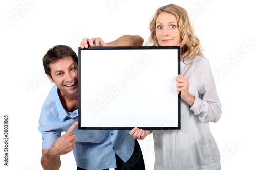 Foto: Couple holding blank picture frame Couple holding blank picture frame