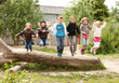 Gruppe Schulkinder springt von Baumstamm