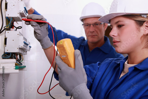 Photo: Tradeswoman using a multimeter Tradeswoman using a multimeter