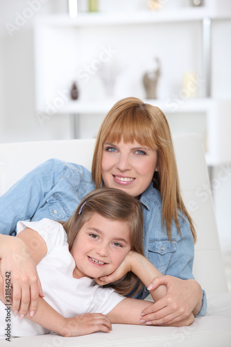 Photo : a 35 years old mother and her little girl lying down on a couch a 35 years old mother and her little girl lying down on a couch