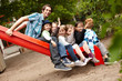 Lehrer und Kinder auf der Rutsche