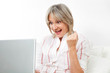 Seniorin jubelt am Laptop
