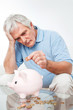 Senior spart Geld in Sparschwein