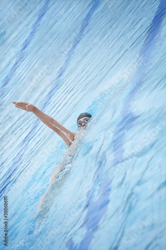 Photo: Swimmer in goggles, cap swimming back crawl Swimmer in goggles, cap swimming back crawl