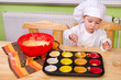 kleiner Junge mit Muffinblech