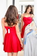 Woman trying red dress in store