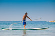 The guy with an oar on a surfboard.