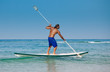 The guy with an oar on a surfboard.