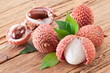 Lychee with leaves on a wooden table.