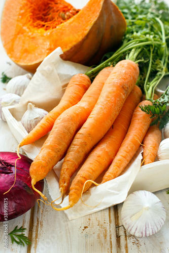 Photo: Pumpkin, carrot, garlic and red onion on white wooden background Pumpkin, carrot, garlic and red onion on white wooden background