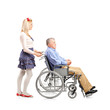Full length portrait of a daughter pushing her dad in a wheelcha