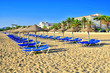 Sandy beach with beds and sun umbrellas