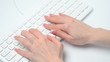 Female hands tping on white pc keyboard
