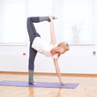 Woman doing stretching yoga exercise at sport gym