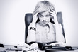 Photo: Portrait of business woman sitting at a desk in the office Portrait of business woman sitting at a desk in the office
