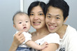 Beautiful young happy family in embrace with little son