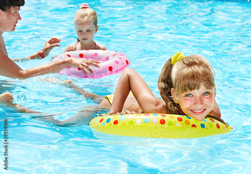 Photo: Happy family with children sitting on inflatable ring. Happy family with children sitting on inflatable ring.
