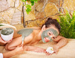 Young woman having clay body mask. Young woman having clay body mask.