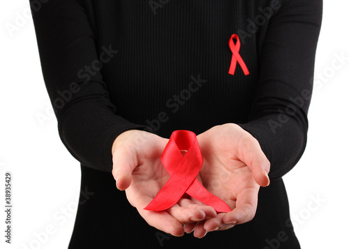 Photo: Woman with aids awareness red ribbon in hands isolated on white Woman with aids awareness red ribbon in hands isolated on white