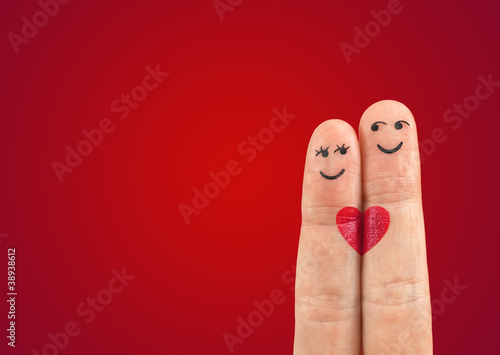 Photo: A happy couple in love with painted smiley and hugging A happy couple in love with painted smiley and hugging
