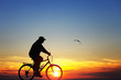 Photo: Silhouette of a man on bike at sunset Silhouette of a man on bike at sunset