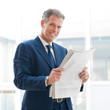 Satisfied businessman read newspaper