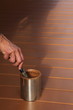 Hand of painter with paint brush in can
