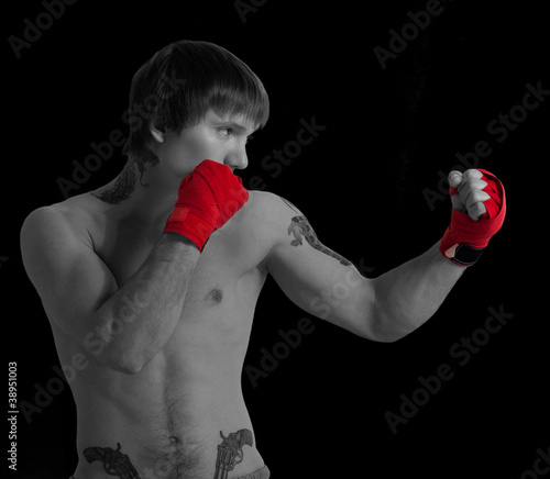 Photo: Young Boxer fighter over over black background Young Boxer fighter over over black background