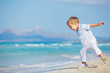 Young cute boy playing happily at pretty beach