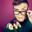 portrait  of a man in big glasses with flowers