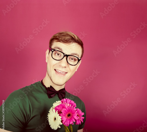 Photo: Young smiling man holding a bouquet of flowers Young smiling man holding a bouquet of flowers