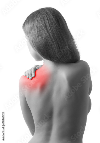 Photo: Rear view of a young woman holding her shoulder in pain, isolate Rear view of a young woman holding her shoulder in pain, isolate