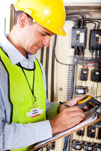 Foto: industrial technician recording machine temperature industrial technician recording machine temperature