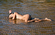 Photo: Nude woman lying in water Nude woman lying in water