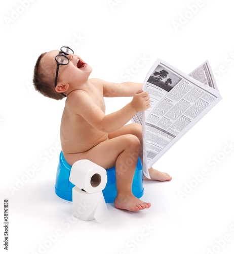 Photo: Little boy sitting on potty with newspaper Little boy sitting on potty with newspaper