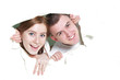 Photo: young happy couple looking out from hole in paper young happy couple looking out from hole in paper