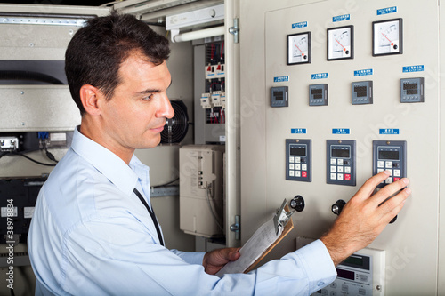 Photo: industrial engineer adjusting modern machine settings industrial engineer adjusting modern machine settings