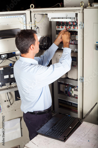 Photo: industrial engineer repairing computerized machine industrial engineer repairing computerized machine