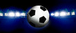 Soccer ball and illuminated stadium at night