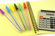 Old calculator and color pens on the yellow writing-book Old calculator and color pens on the yellow writing-book