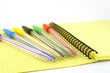 Color pens on the yellow writing-book Color pens on the yellow writing-book