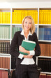 Business Frau steht vor Bücherregal