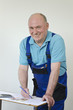 Handwerker mit Bauplan, Taschenrechner und Geld