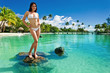 Young woman in white bikini standing on tropical beach Young woman in white bikini standing on tropical beach