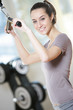 Photo: smiling young woman doing on a weight machine at the health club smiling young woman doing on a weight machine at the health club