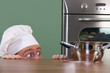 Funny young chef strange looking at pot
