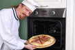 Photo: young chef with italian pizza in kitchen young chef with italian pizza in kitchen
