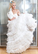 The young woman with a wedding dress in hands dreams of wedding